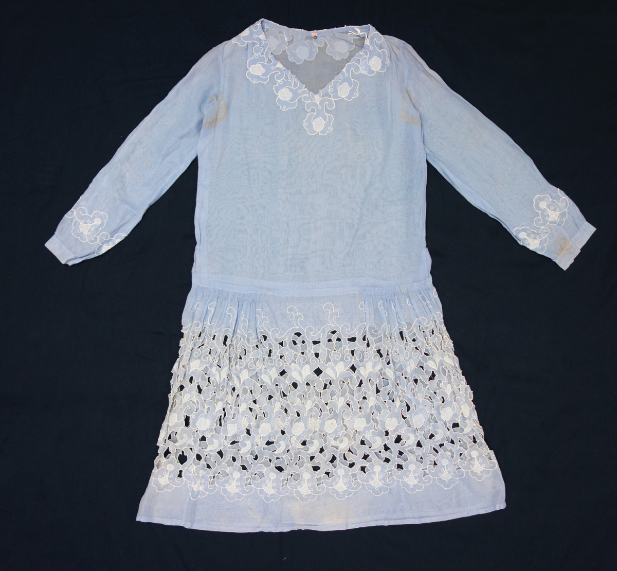 Dress made of a powder blue cotton material and decorated with cutwork and abstract organic shapes, all in white.  The Netherlands, 1920s.