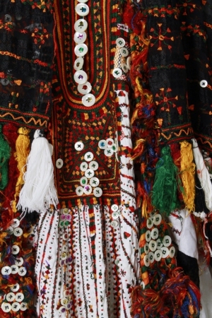 Detail of the embroidery on a black headdress and white wedding dress from the Siwa oasis, showing the traditional Siwa colours and the mother-of-pearl buttons, 1970's.