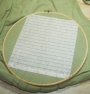 Piece of waste canvas used as a guide for embroidery.
