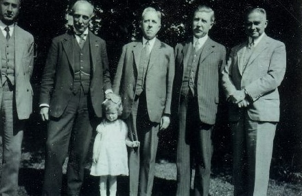 Fig. 9. "De Beentjes."  A group of Leiden professors that met for a walk every Wednesday afternoon at 15.30 under the clock of the (new) Academic Hospital. From left to right: Prof. Eduard Meijers (1880-1954), Prof. Jan van der Hoeve (1878-1952), Prof. Johan Huizinga (1872-1945), Prof. Gerrit Jan Heering (1879-1955), and Ton Barge. The little girl is said to be Laura, Huizinga's daughter (born in 1941), which would date the photograph to the end of the war.