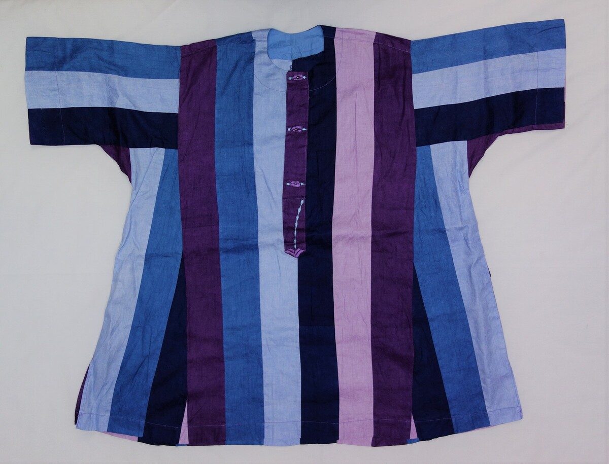Man's tunic from Mali, early 21st century. It is made from dyed strips of damask woven cloth (bazin). The strips were then sewn together to create the ground material for the garment (TRC 2008.0272).