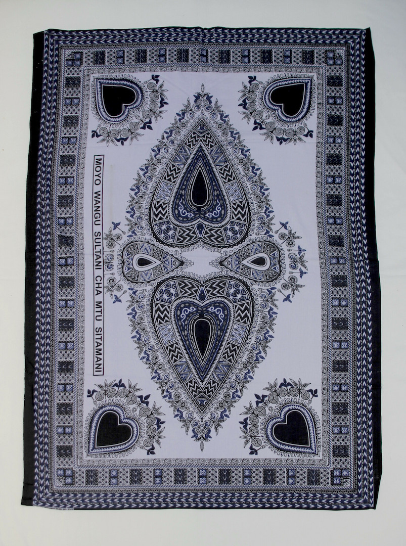 Single kanga with a central design, in black, blue and lilac. The design is based on a Vlisco cloth called the Cigar Label (actually based on a late 19th century label around a cigar). Kenya, 2010 (TRC 2013.0131).