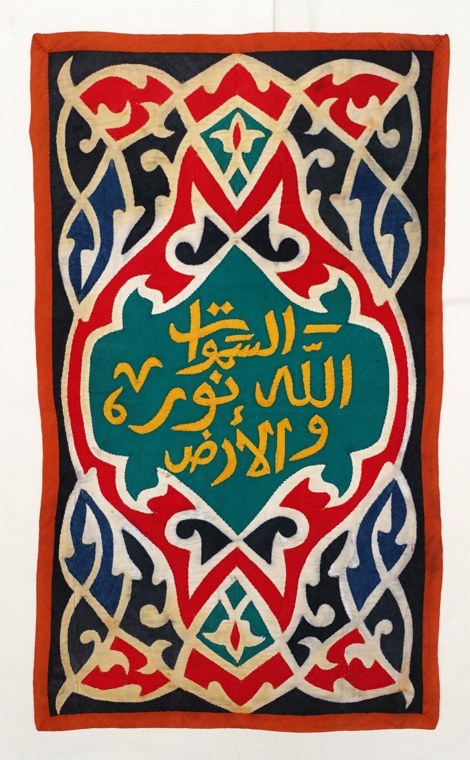 An applique panel (khayamiya) from Egypt with Arabic calligraphy: “الله نور السماوات والأرض” –  “God is the light of the heavens and the earth”, based on ayah 35 from surah Al-Nur (20th century) (TRC 2022.1543).