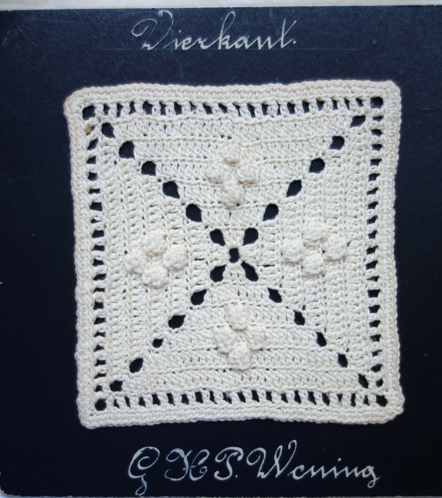 Piece of black card with a crocheted square divided into four triangles, each with four bobbles. There is the text: "Vierkant  G H P Wening" (TRC 2023.2805.071).