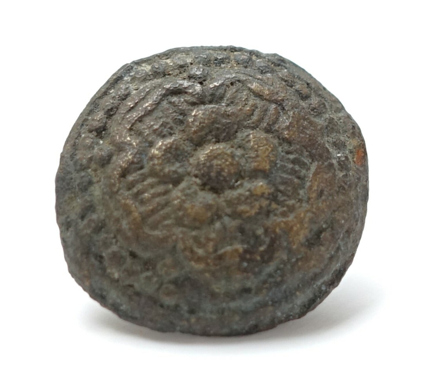 A slightly domed metal button with an alpha-type shank, with flowers within flowers inside a dotted border on the front. The Netherlands, 15th-16th century (TRC 2024.2582).