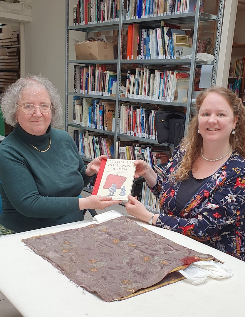 Martine Benot-Teunissen (right) presents the new book about archaeological textiles from the Netherlands to TRC Director, Dr Gillian Vogelsang-Eastwood (left). Monday 10th June, 2024. 