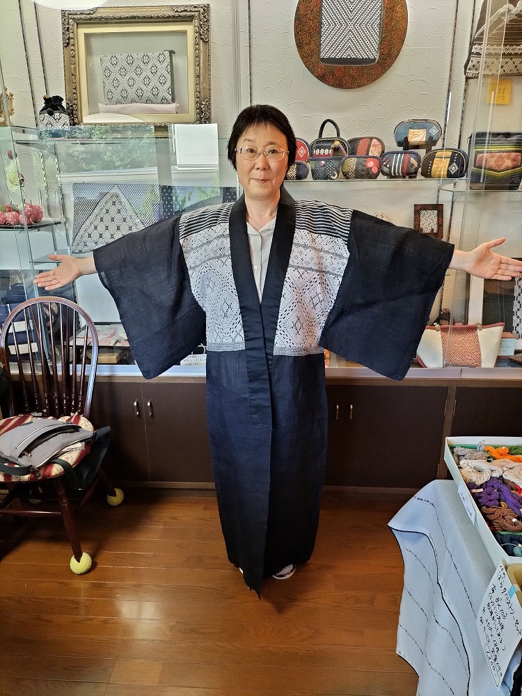 Author wearing an antique kogin garment, the legacy of Chuzaburo Tanaka, at the Sato Yoko Kogin Tenjikan.