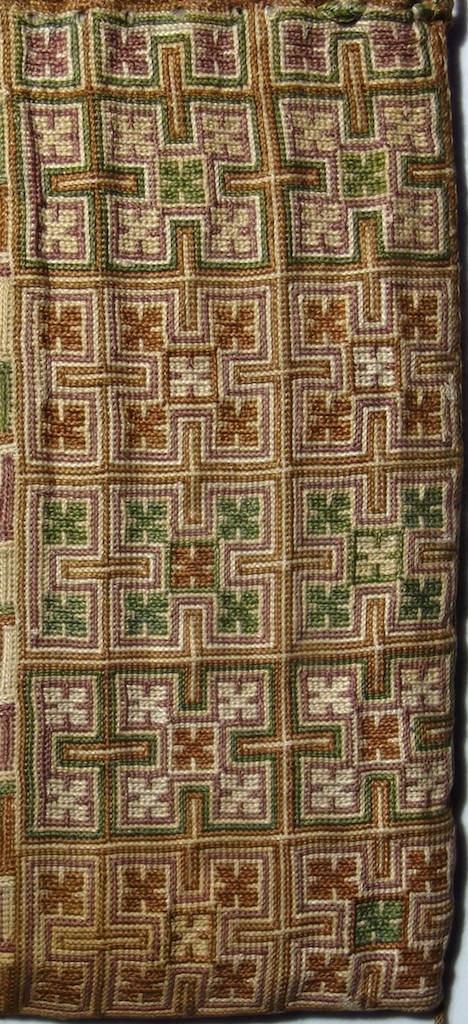 Pattern 2: Rows of squares enclosing ornate X shapes in various colour combinations. Photograph by author.