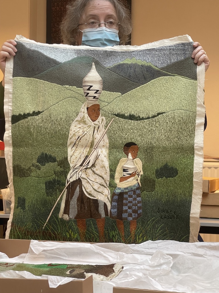 Gillian Vogelsang showing a modern embroidery from Rwanda, produced by the Savane  Kabuye workshop (TRC 2021.2052).