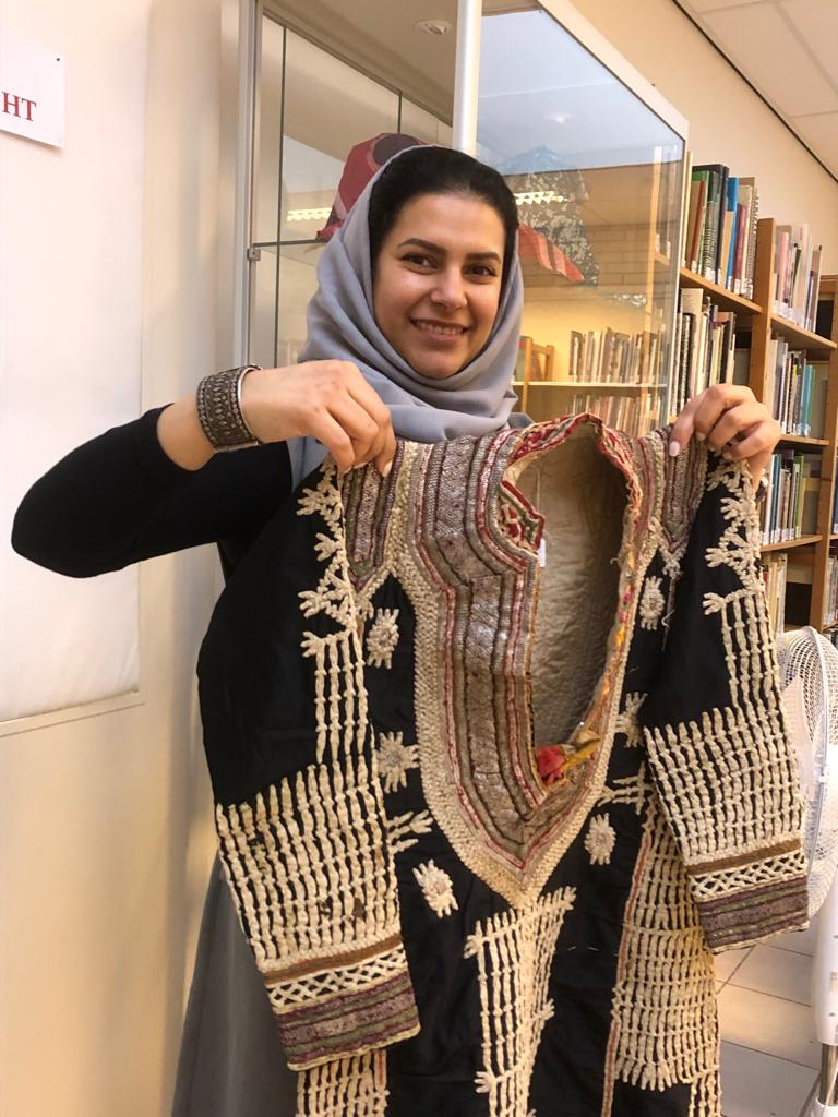 HE The Ambassador of Yemen to the Netherlands, Mrs Sahar Ghanem, at the TRC on 31st January 2023, holding an embroidered Yemeni woman's dress (TRC 1997.0213).