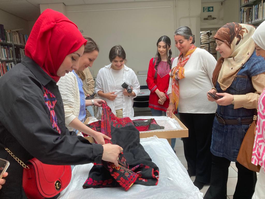 A group of women with a Middle Eastern background at the TRC discussing Syrian garments. Photograph by Maria Linkogle.