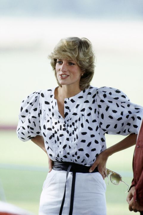 Princess Diana watching a polo match in Cirencester, in 1983. She is wearing a blouse with black spots, and a white skirt.