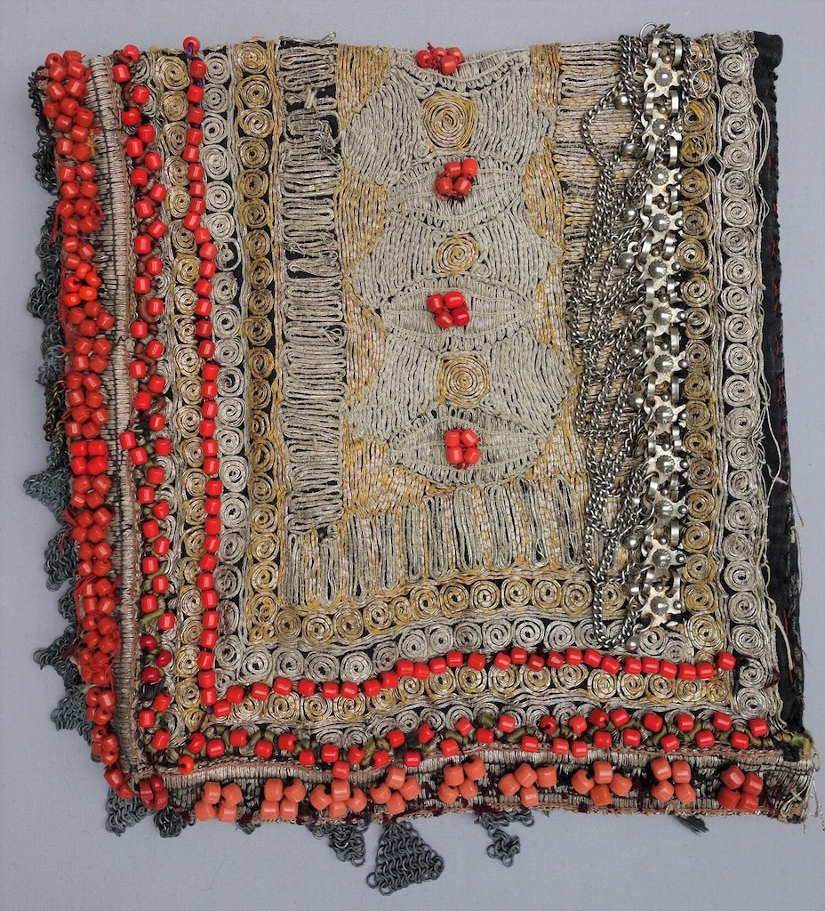 Woman's head covering from Yemen, decorated with coral beads, metal chains and embroidery, late 20th century (TRC 1997.0203).